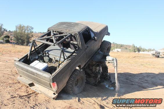 Modified off-road truck with roll cage, stuck in dirt