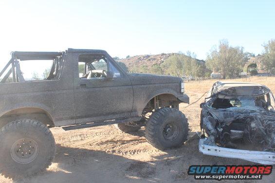1992 Ford Bronco side view, towing a crushed car