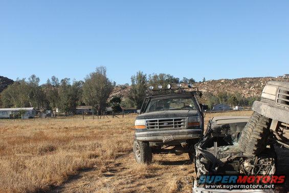 1992 Ford Bronco with roof rack and off-road lights, 3q-front view, parked next to wrecked car
