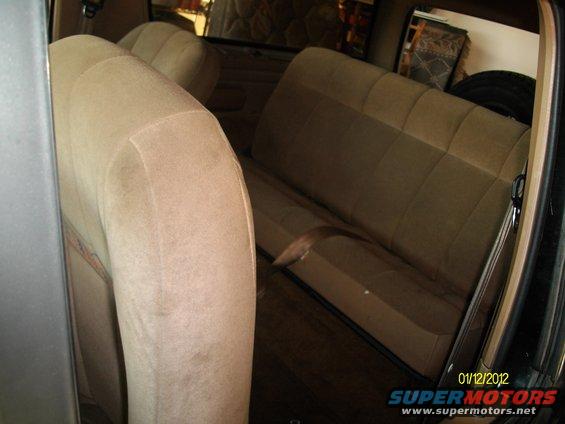 Tan cloth seats and interior of a vehicle, viewed from the side
