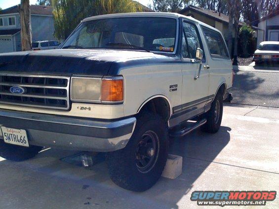 White 1989 Ford Bronco with a dark hood, parked on a driveway