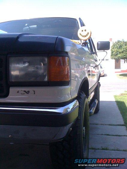 Front corner of a white Ford F-Series truck, showing headlights and grille