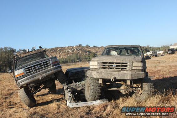 1992 Ford Bronco and another Ford truck stuck in mud off-road