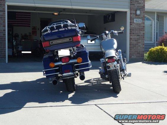 Rear view of blue Harley-Davidson motorcycle with a silver one beside it