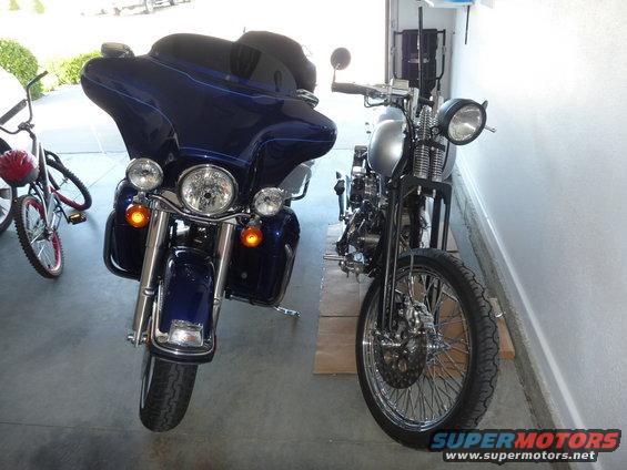 blue touring motorcycle and a silver chopper motorcycle parked in a garage
