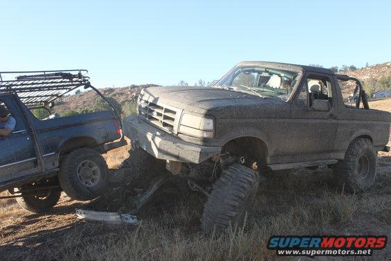 Mud-covered 1992 Ford Bronco stuck in dirt, front grille visible