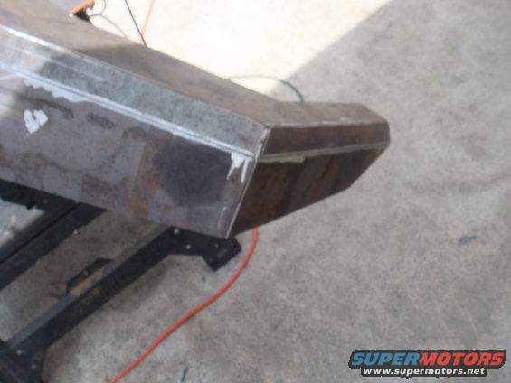 Custom steel bumper section on a stand, showing welds and raw metal