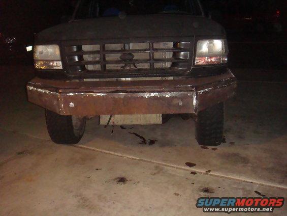 Dark 1992 Ford Bronco with a custom rusty metal bumper and a grille visible