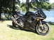 2008 Yamaha R1 - Black Yamaha R6 motorcycle parked on grass by a lake, with trees and water in the background.