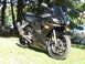 2008 Yamaha R1 - A black Yamaha R6 motorcycle is parked on a grassy area next to a body of water, with trees in the background.