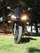 2008 Yamaha R1 - A black motorcycle is parked on a grassy lawn in front of trees, with its headlights illuminated.