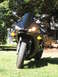 2008 Yamaha R1 - A black Yamaha motorcycle is shown from the front, parked on a grassy lawn with a tree and building in the background.
