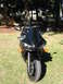 2008 Yamaha R1 - A black motorcycle is parked on a grassy area with trees in the background.