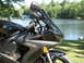 2008 Yamaha R1 - Yamaha R6 motorcycle parked by a lake with trees and a house in the background.