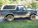 1992 Ford Bronco - Muddy 1992 Ford Bronco parked on grass.