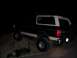 1992 Ford Bronco - This lifted Ford Bronco is shown off-roading on a dirt incline in the dark.