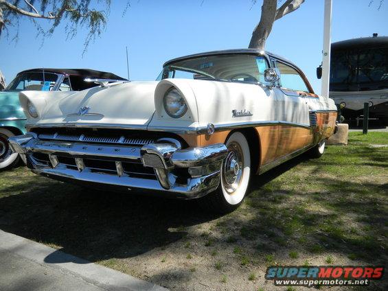 1955 Mercury Montclair, white and wood-paneled, 3q-front view. Another car is partially visible to the left