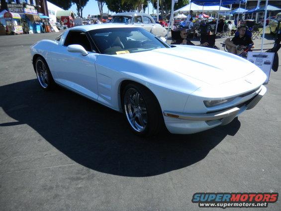White custom sports car with chrome wheels parked outdoors