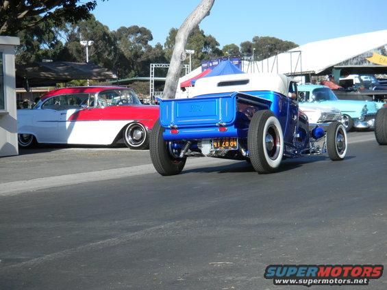 Blue hot rod pickup truck rear view with whitewall tires and custom license plate