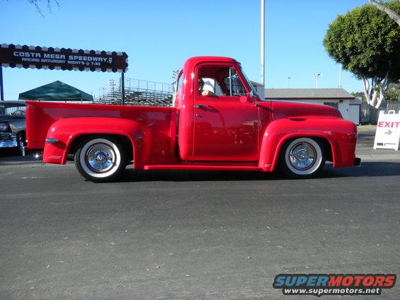 Red 1953 Ford F-100 pickup truck, side view, lowered with whitewall tires