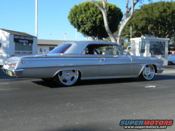 Silver coupe with custom wheels, lowered suspension, and chrome trim