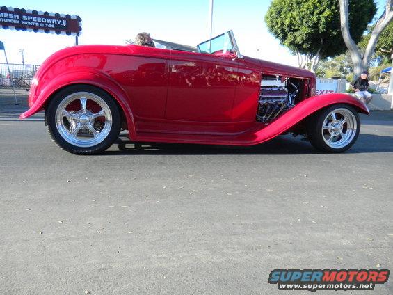 Red 1932 Ford hot rod convertible with exposed engine and chrome wheels