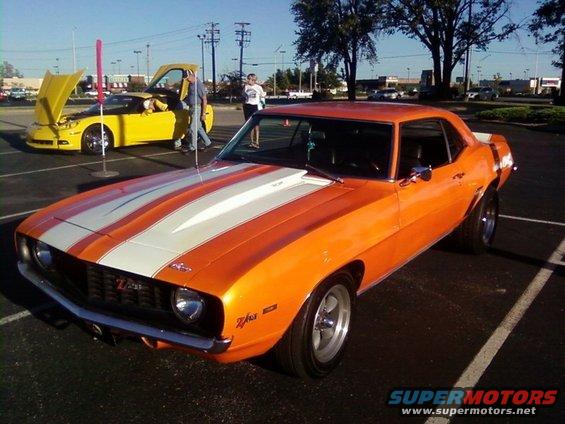 Orange 1969 Chevrolet Camaro Z/28 with white racing stripes, front 3/4 view