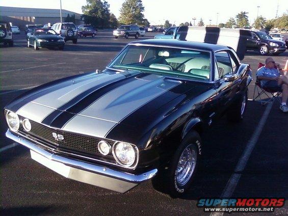 Black 1967 Chevrolet Camaro SS with silver racing stripes and chrome wheels parked in a lot