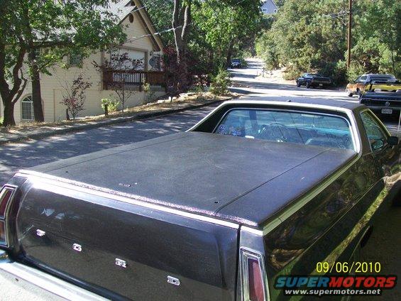 Rear view of a 1972 Ford Ranchero with a black tonneau cover parked on a residential street
