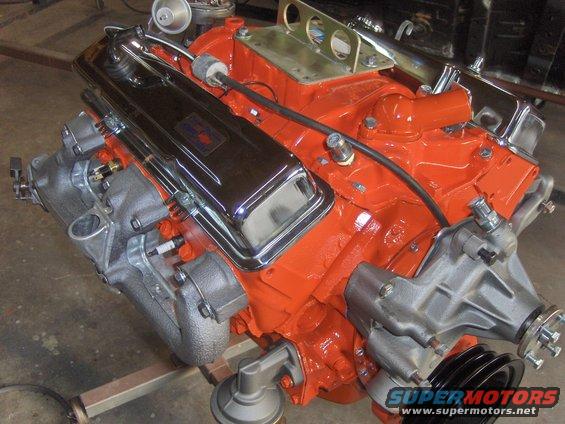 V8 engine with orange block, chrome valve covers, and a water pump