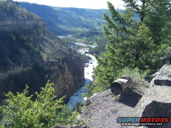 Trash can on cliff edge overlooking river canyon
