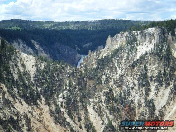 Yellowstone canyon landscape with a waterfall and pine trees