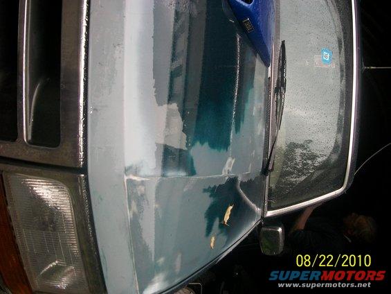 Front fender and headlight of a 1993 Ford Bronco with peeling paint and primer showing