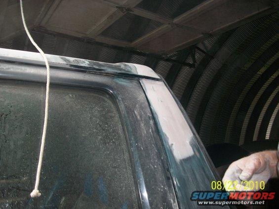 1993 Ford Bronco rear pillar being prepped for paint, showing body filler