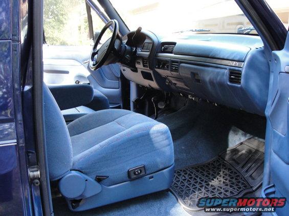 Blue fabric seats and dashboard of a truck interior. Power seat controls visible