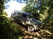1992 Ford Bronco - This SUV is navigating a challenging off-road trail, covered in mud from the journey.