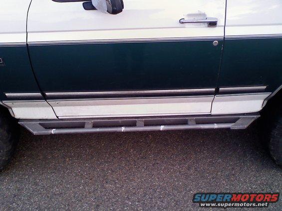 White and dark green 1996 Ford Bronco side view with metal step sliders