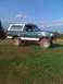 1992 Ford Bronco - This modified 1992 Ford Bronco sits on a grassy incline under a blue sky.