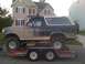 1992 Ford Bronco - A 1992 Ford Bronco, heavily coated in mud, is transported on a U-Haul trailer.