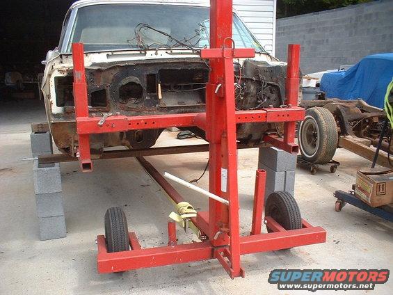 1967 Ford Galaxie front clip on a red automotive lift, with another car frame in the background