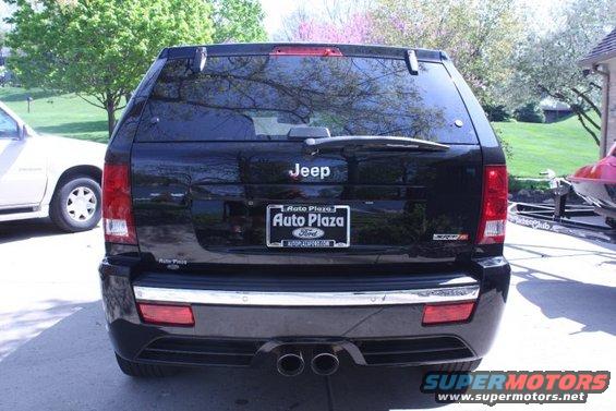 Black Jeep SUV rear view, chrome trim, dual exhaust, license plate frame from Auto Plaza Ford