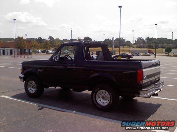 Black Ford Bronco with a silver stripe on the tailgate, parked in a lot