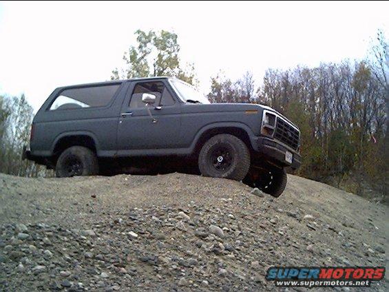 Dark gray Ford Bronco on a gravel hill, side view