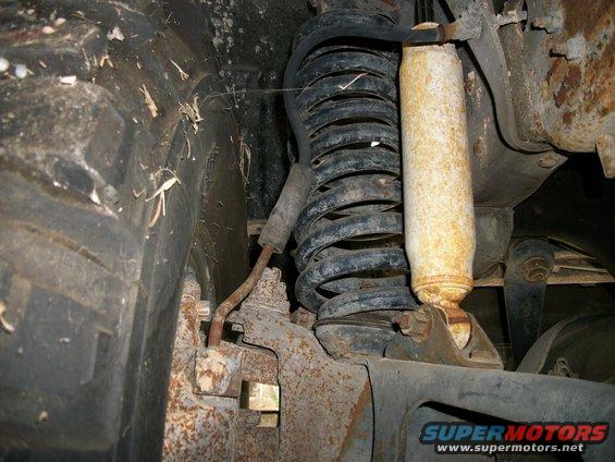 Close-up of rusty suspension with coil spring and shock absorber