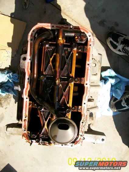 engine oil pan with internal components, some oil residue visible