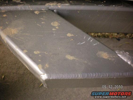 Metal slider with dirt and scratches, showing visible welds
