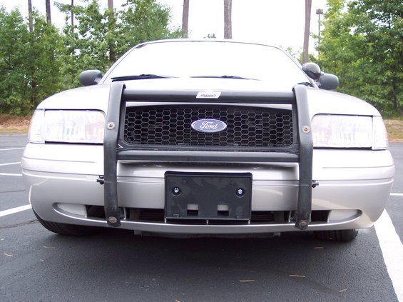 Silver 2001 Ford Crown Victoria with a black push bar and honeycomb grille