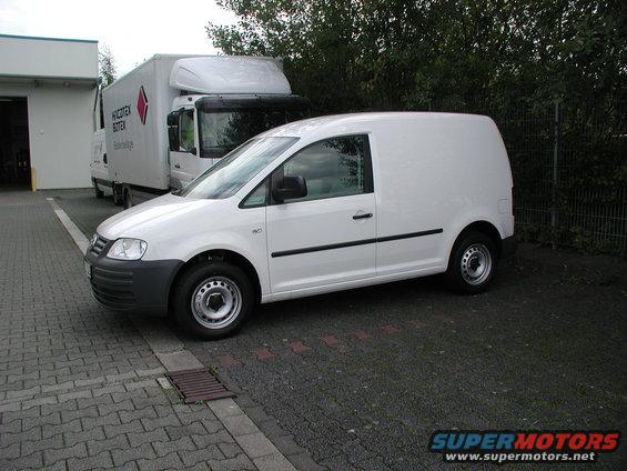 White panel van parked next to a semi-truck