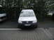 2009 Holden Commodore - A white Volkswagen Caddy van is parked in a lot with trees in the background.