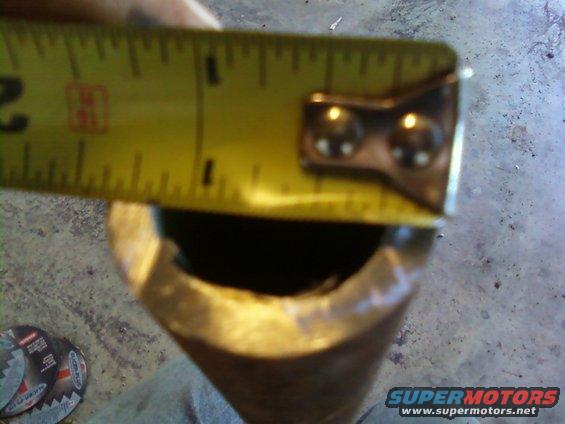 Measuring a metal pipe with a yellow tape measure